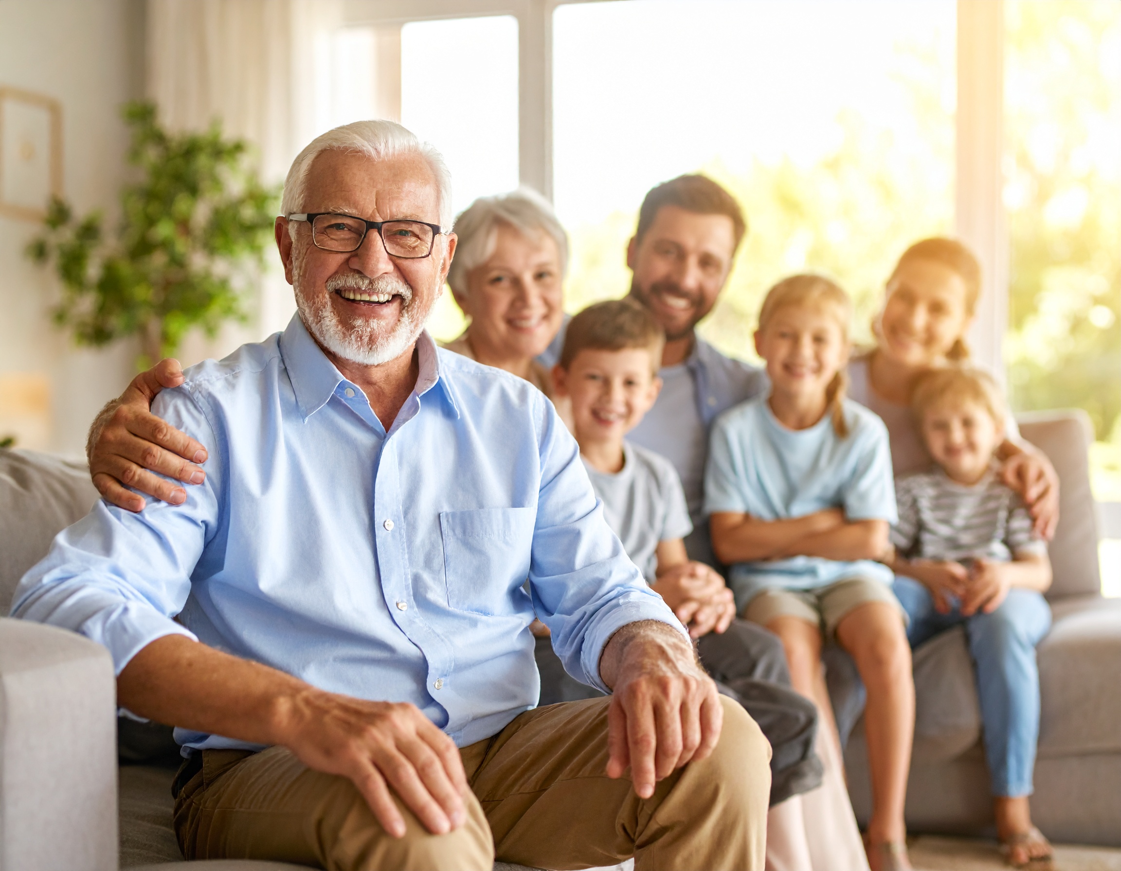 Firefly_grand father sitting on the couch with family sitting behind bright sunny room 698553